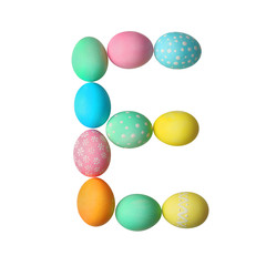 Letter E made of Easter eggs on light background