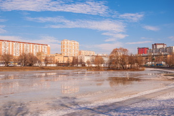 Fototapeta na wymiar Frozen pond in the park of the modern city