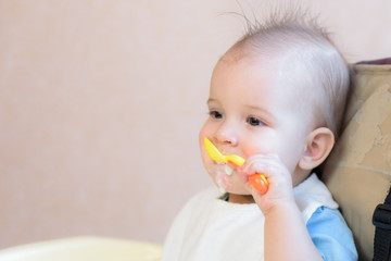 baby holding a spoon in his mouth