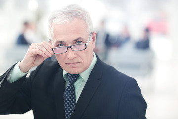 Portrait of mature businessman with  colleagues interacting on b