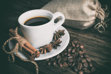 Coffee composition with black coffee, cinnamon on the old wooden
