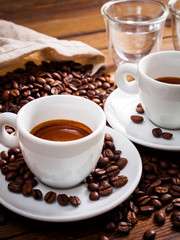 Two cup of espresso with a lot of coffee beans, on wooden table, vertical edit - 130872346