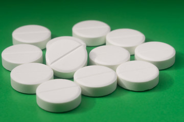 Macro shot of white drugs on green background