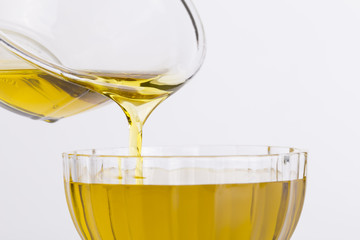 Olive oil flows from a glass bowl