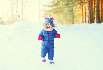 smiling child on snow in winter day