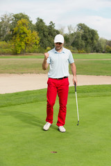 Golfer. Satisfied golfer after successful putting shot