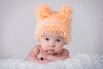 Newborn baby in a knitted cap with ears.