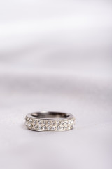 Wedding diamond ring on white satin background