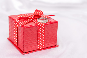 Red gift box with red bow and diamond ring