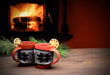 Cup with Christmas ornament near fireplace. 