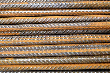 closeup of a stack of rusty metal deformed reinforcement bars / steel rods from a construction site 
