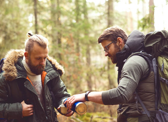 Man with a beard and his friend hiking in a forest