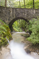 Fototapeta na wymiar Wasser im Bach mit Brücke - Natur