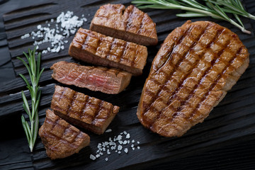 Close-up of whole and sliced grilled beef medallion steaks