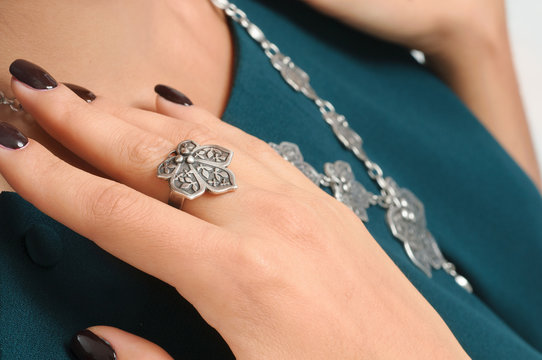 close-up woman hand with ring on finger and necklace on backgrou
