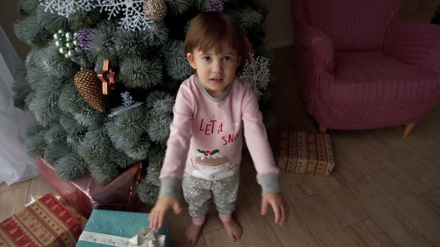 Small children enjoy gifts in the Christmas tree