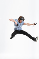 Bearded screaming man wearing virtual reality device jumping