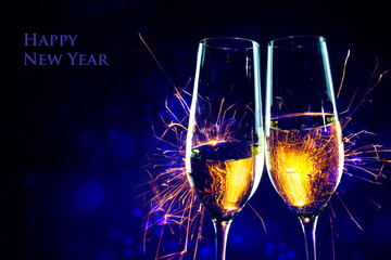 New Year party time with two champagne glasses and sparklers against a dark blue background, sample...