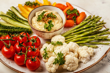 Healthy homemade hummus with assorted fresh vegetables.