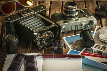 Retro Fotokameras auf einem Tisch / Alte Retro Fotoapparate auf einem Tisch mit Fotografien, Negativen und Filme mit Textfreiraum.