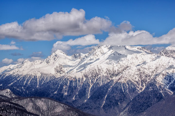 Obraz na płótnie Canvas Beautiful snowy mountain peaks and blue sky with clouds scenic winter landscape of the Main Caucasus ridge