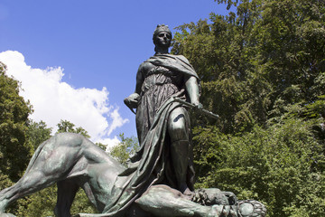 Woman stepping on lion sculpture at 