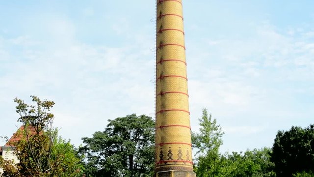 A factory chimney in an urban area - the blue sky in the background
