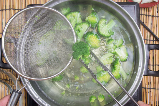Chef boiling Broccoli in pan