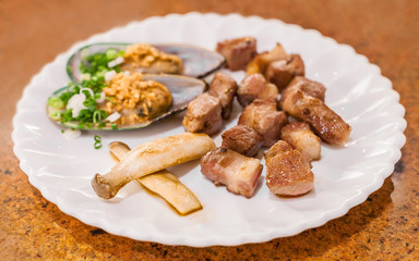 grilled pork chop slice with sea mussel and shiitake mushroom on