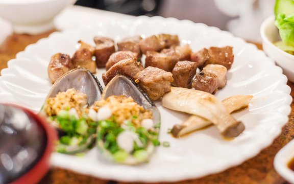 grilled pork chop slice with sea mussel and shiitake mushroom on
