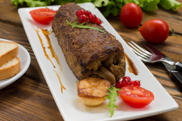 Meatloaf stuffed with mushrooms  sauce and berries. Wooden rustic background. Close-up