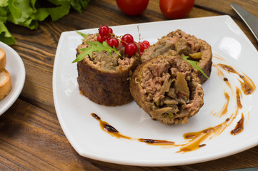 Meatloaf stuffed with mushrooms  sauce and berries. Wooden rustic background. Close-up