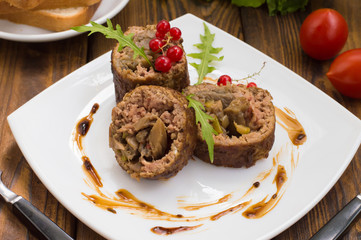 Meatloaf stuffed with mushrooms  sauce and berries. Wooden rustic background. Close-up