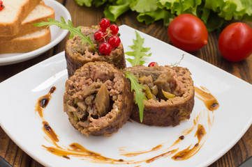 Meatloaf stuffed with mushrooms  sauce and berries. Wooden rustic background. Close-up