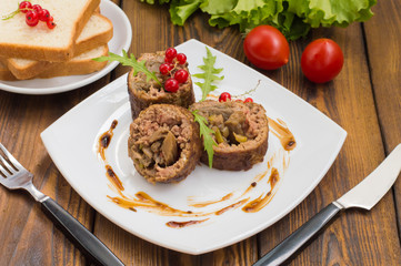 Meatloaf stuffed with mushrooms  sauce and berries. Wooden rustic background. Close-up