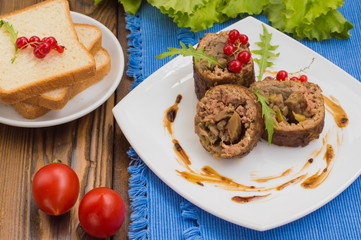 Meatloaf stuffed with mushrooms  sauce and berries. Wooden rustic background. Close-up