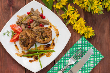Meatloaf stuffed with mushrooms  sauce and berries. Wooden rustic background. Top view. Close-up