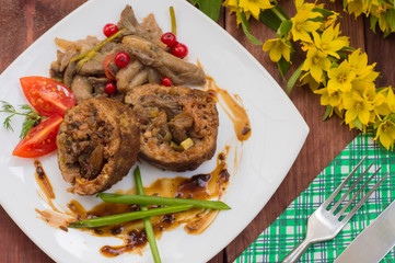 Meatloaf stuffed with mushrooms  sauce and berries. Wooden rustic background. Top view. Close-up