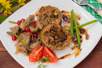 Meatloaf stuffed with mushrooms sauce and berries. Wooden rustic background. Close-up
