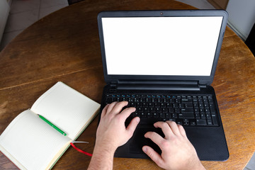 Man typing on a laptop computer in vintage kitchen.