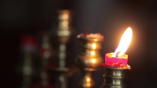 Color footage of a candle in a candlestick, put out with a tool. 