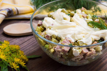 Russian salad Olivier . Wooden table. Close-up
