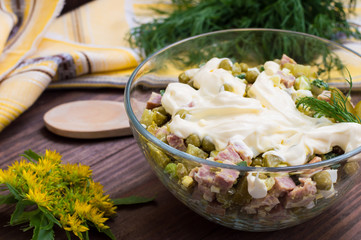 Russian salad Olivier . Wooden table. Close-up