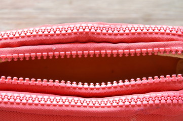 red fabric purse zipper slide opened on wooden board