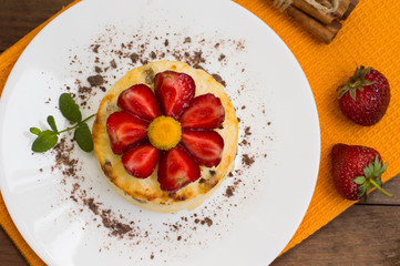 Curd pudding with raisins and strawberry. Wooden rustic table. Close-up. Top view