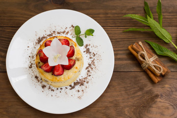 Curd pudding with raisins and strawberry. Wooden rustic table. Close-up. Top view