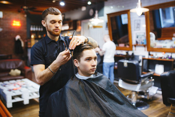Obraz premium Master cuts hair of men in the barbershop