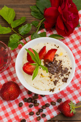 Semolina with grated chocolate and strawberry on a fabulously delicious tomorrow. Wooden background. Top view. Close-up