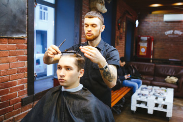 Master cuts hair of men in the barbershop