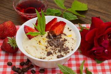 Semolina with grated chocolate and strawberry on a fabulously delicious tomorrow. Wooden background. Top view. Close-up